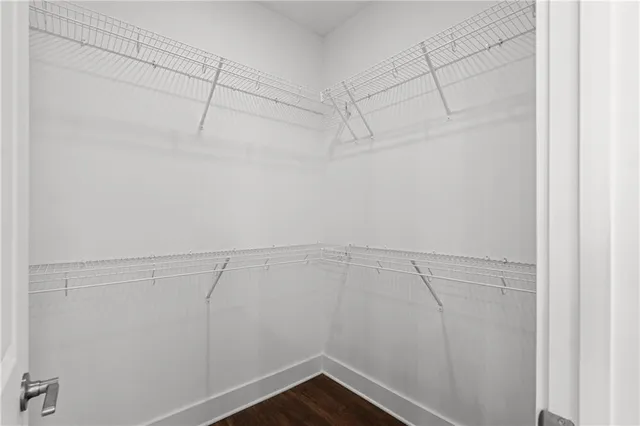 a view of hallway with wooden floor and cabinets