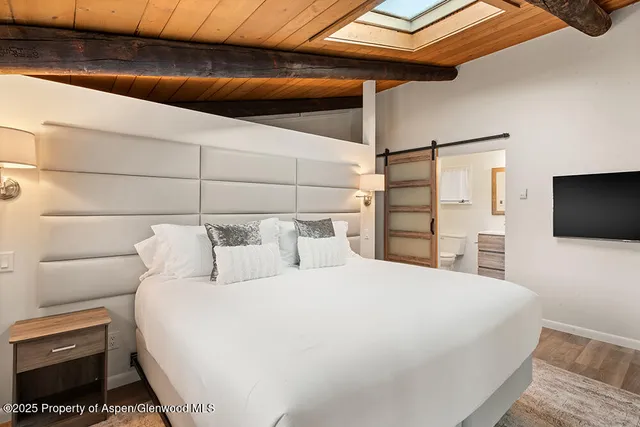 a bedroom with a bed and a flat screen tv