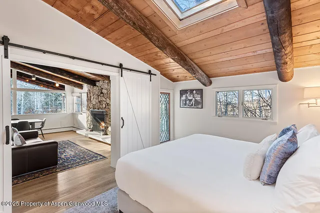 a bedroom with a bed a couch and large window