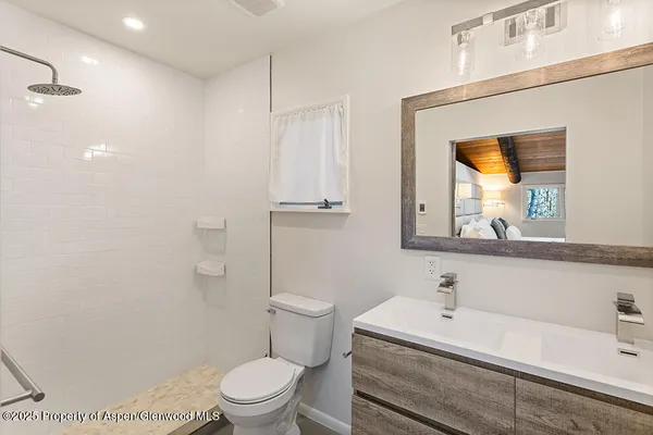 a bathroom with a sink a toilet and a mirror