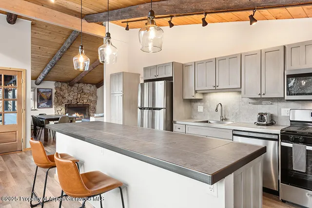 a kitchen with stainless steel appliances granite countertop a sink a stove and a refrigerator