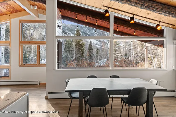 a view of a dining room with furniture a chandelier and wooden floor