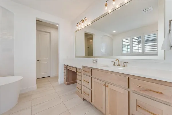 a spacious bathroom with a bathtub sink and mirror