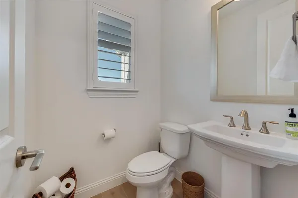 a bathroom with a sink toilet and a mirror