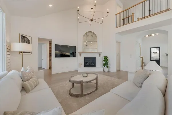 a living room with furniture a flat screen tv and a chandelier