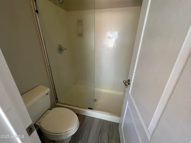 a white toilet sitting next to a shower
