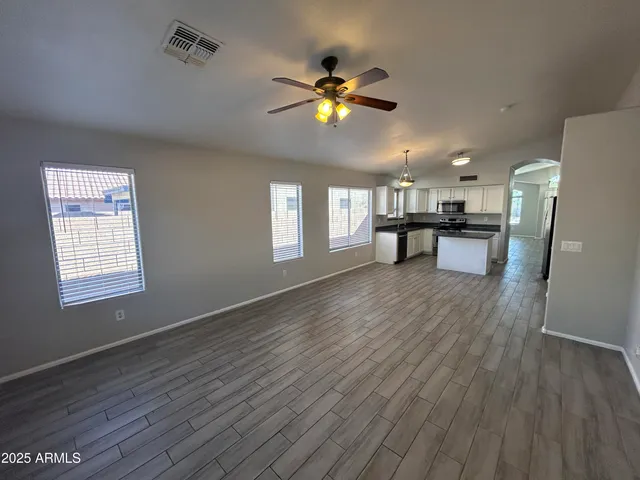 a view of a livingroom with furniture wooden floor and a ceiling fan