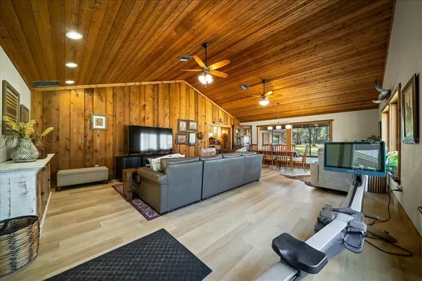 a view of an empty room with wooden floor and windows