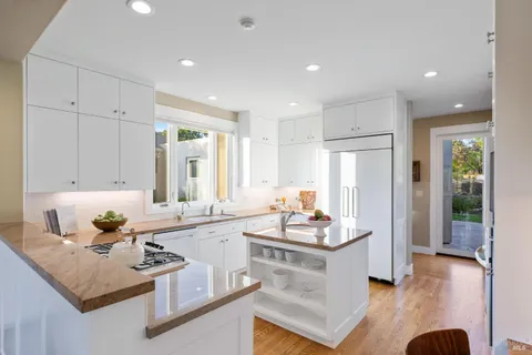 a kitchen with kitchen island granite countertop a sink stove and cabinets