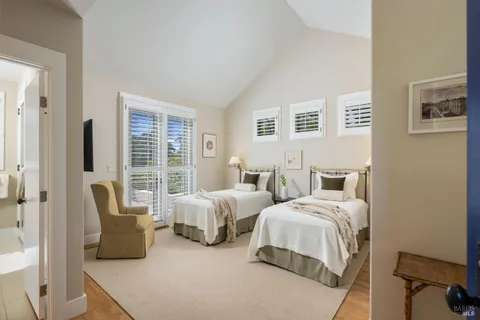 a spacious bedroom with two beds and large window