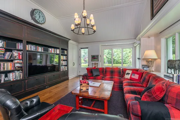 a living room with furniture a flat screen tv and a large window