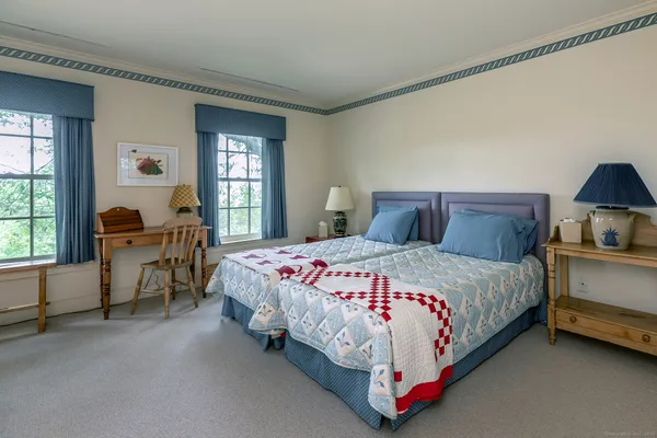 a bedroom with a bed chair and a window