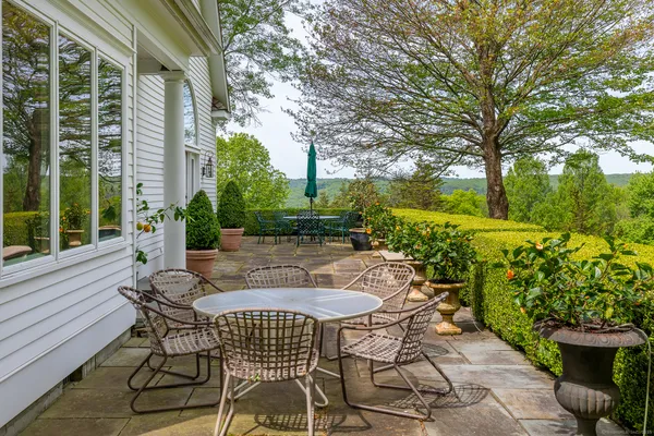 a view of a patio with table and chairs and potted plants
