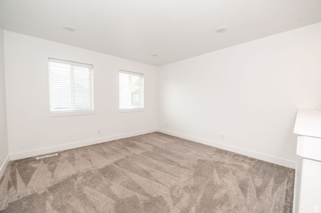 46 West 460 Smithfield, UT 84335 - Photo 24 of 31 Spacious room featuring neutral carpeting, two windows with blinds, recessed lighting, and crisp white walls