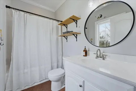 a white toilet sitting next to a bathroom sink and vanity