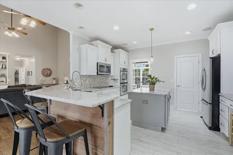 a kitchen with stainless steel appliances granite countertop a sink refrigerator and cabinets