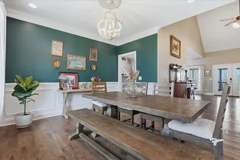 a view of a dining room with furniture a chandelier and wooden floor