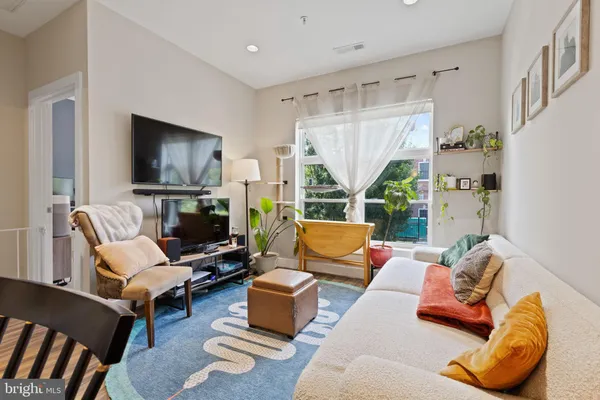 a living room with furniture a large window and a flat screen tv