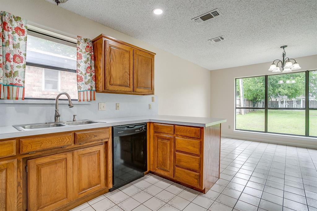 8613 Silver Creek Road White Settlement, TX 76108 - Photo 11 of 40 a kitchen with sink cabinets and window