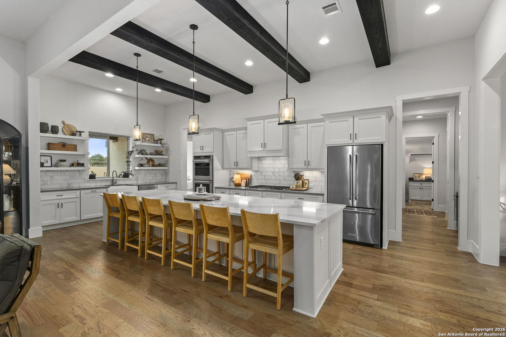 71 Sabinas Creek Ranch Road Boerne, TX 78006 - Photo 11 of 38 a kitchen with stainless steel appliances kitchen island granite countertop a table chairs refrigerator and microwave