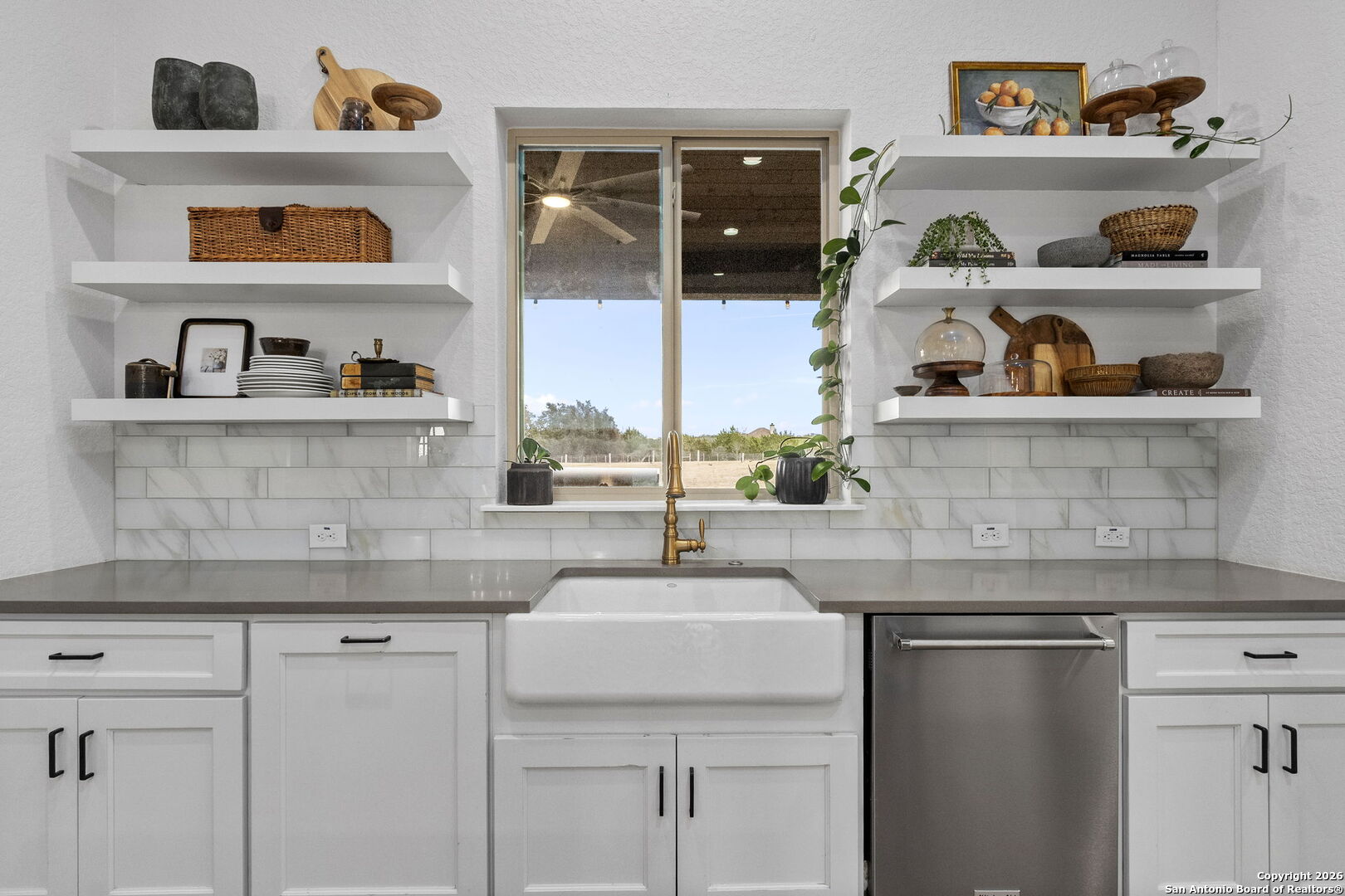 71 Sabinas Creek Ranch Road Boerne, TX 78006 - Photo 12 of 38 a kitchen with white cabinets and wooden floor