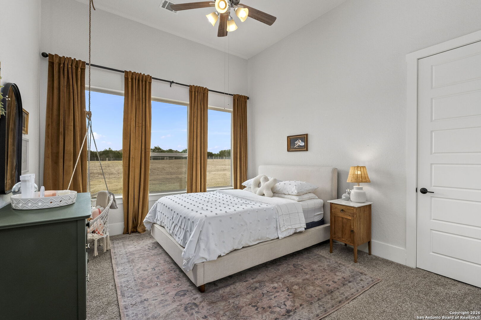 71 Sabinas Creek Ranch Road Boerne, TX 78006 - Photo 26 of 38 a bedroom with a bed and a chandelier