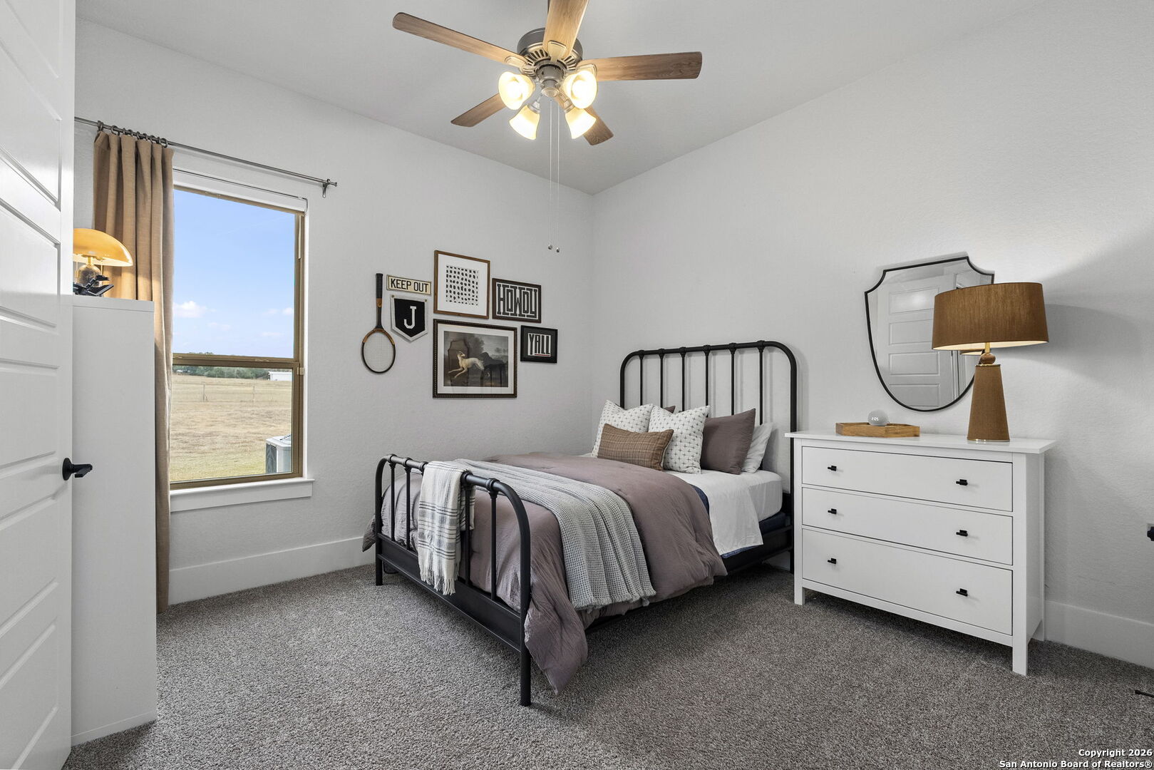 71 Sabinas Creek Ranch Road Boerne, TX 78006 - Photo 27 of 38 a spacious bedroom with a bed and a chandelier