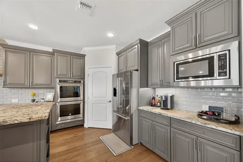 a kitchen with refrigerator a microwave a stove and cabinets