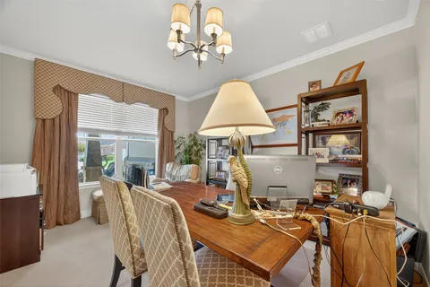 a view of a dining room with furniture a chandelier and a window
