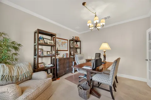 a living room with furniture a chandelier and a bookshelf