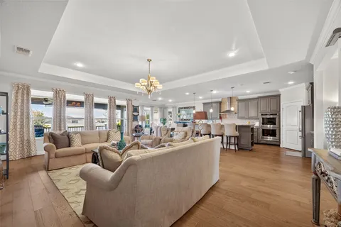 a living room with furniture kitchen and a chandelier