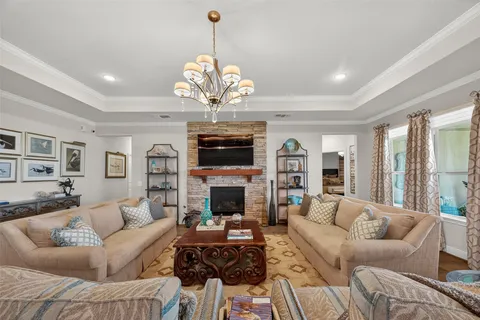 a living room with furniture a chandelier and a fireplace