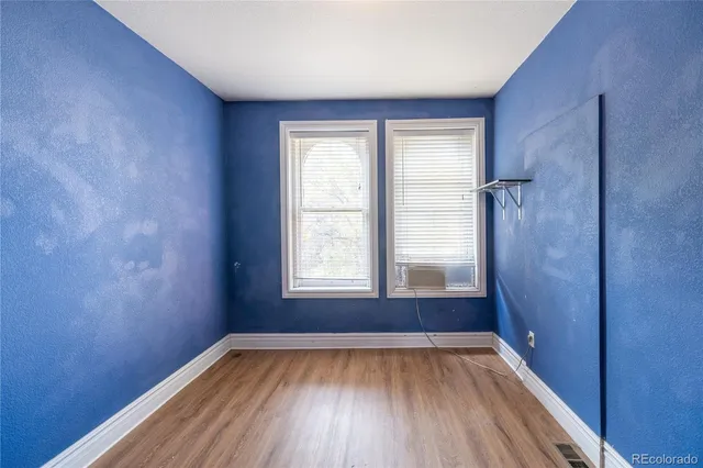 a view of a room with wooden floors and window
