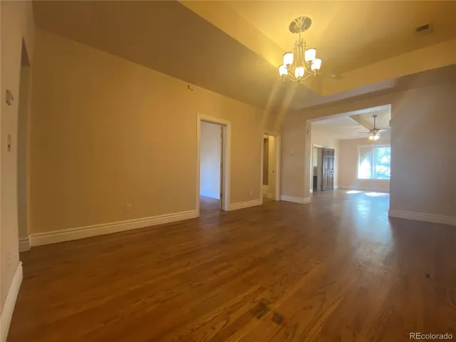 wooden floor in an empty room with a chandelier