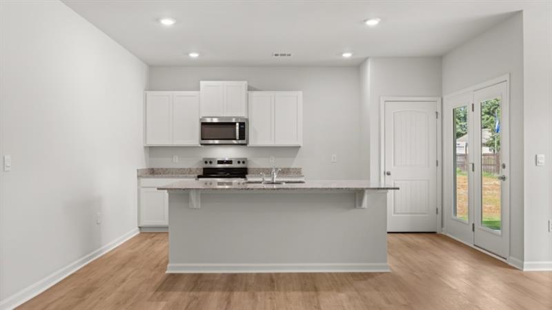 29 Coggins Place Northeast Rome, GA 30165 - Photo 6 of 41 a kitchen with stainless steel appliances a sink a stove a microwave and cabinets
