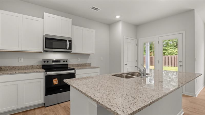 29 Coggins Place Northeast Rome, GA 30165 - Photo 7 of 41 a kitchen with granite countertop a sink a stove top oven a counter space and cabinets