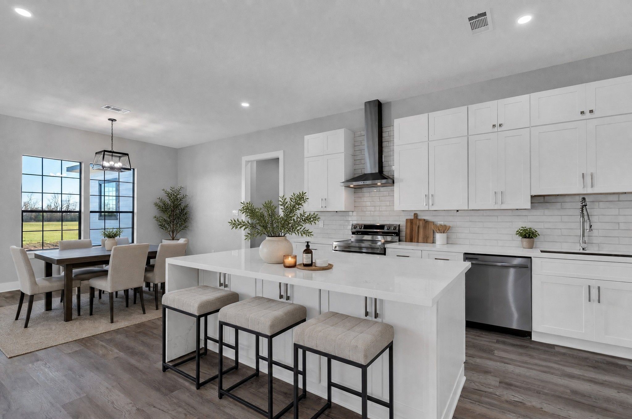 519 Chuckwagon Trail Angleton, TX 77515 - Photo 9 of 34 a kitchen with a dining table chairs and white cabinets