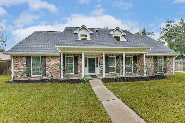 front view of a brick house with a yard