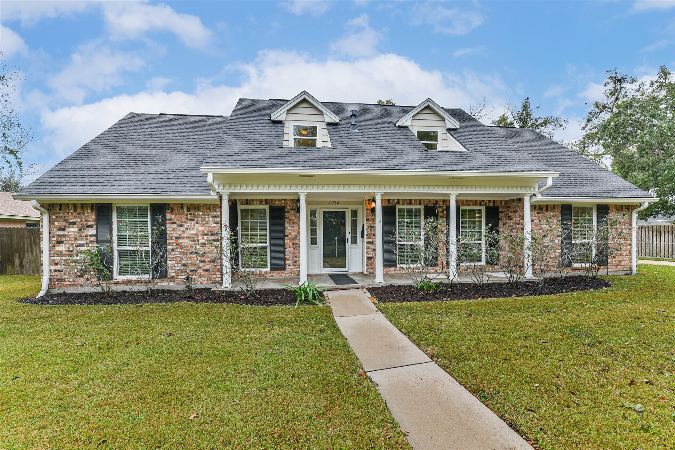 front view of a brick house with a yard