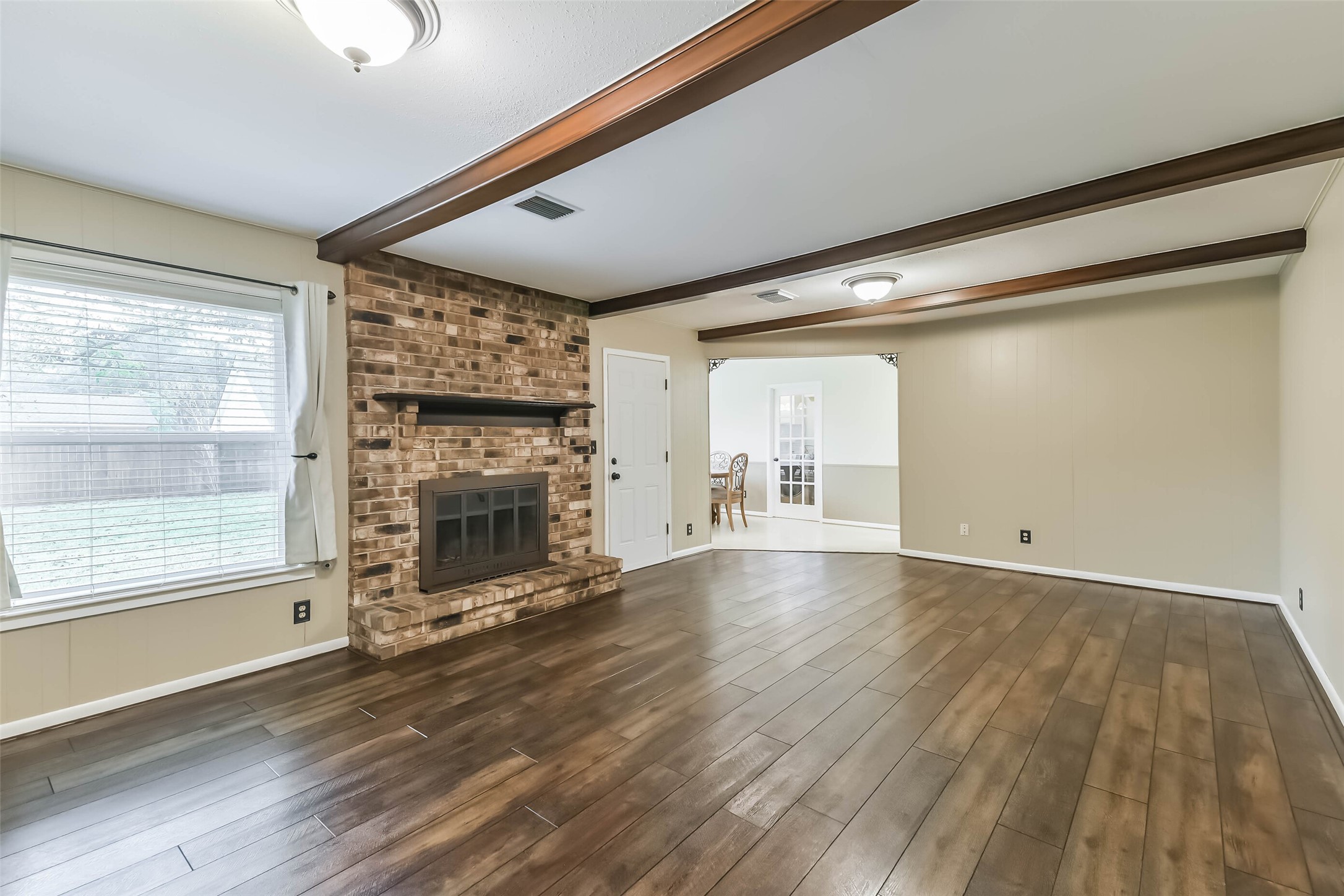 1210 Timber Lane Rosenberg, TX 77471 - Photo 3 of 48 a view of an empty room with wooden floor and a window