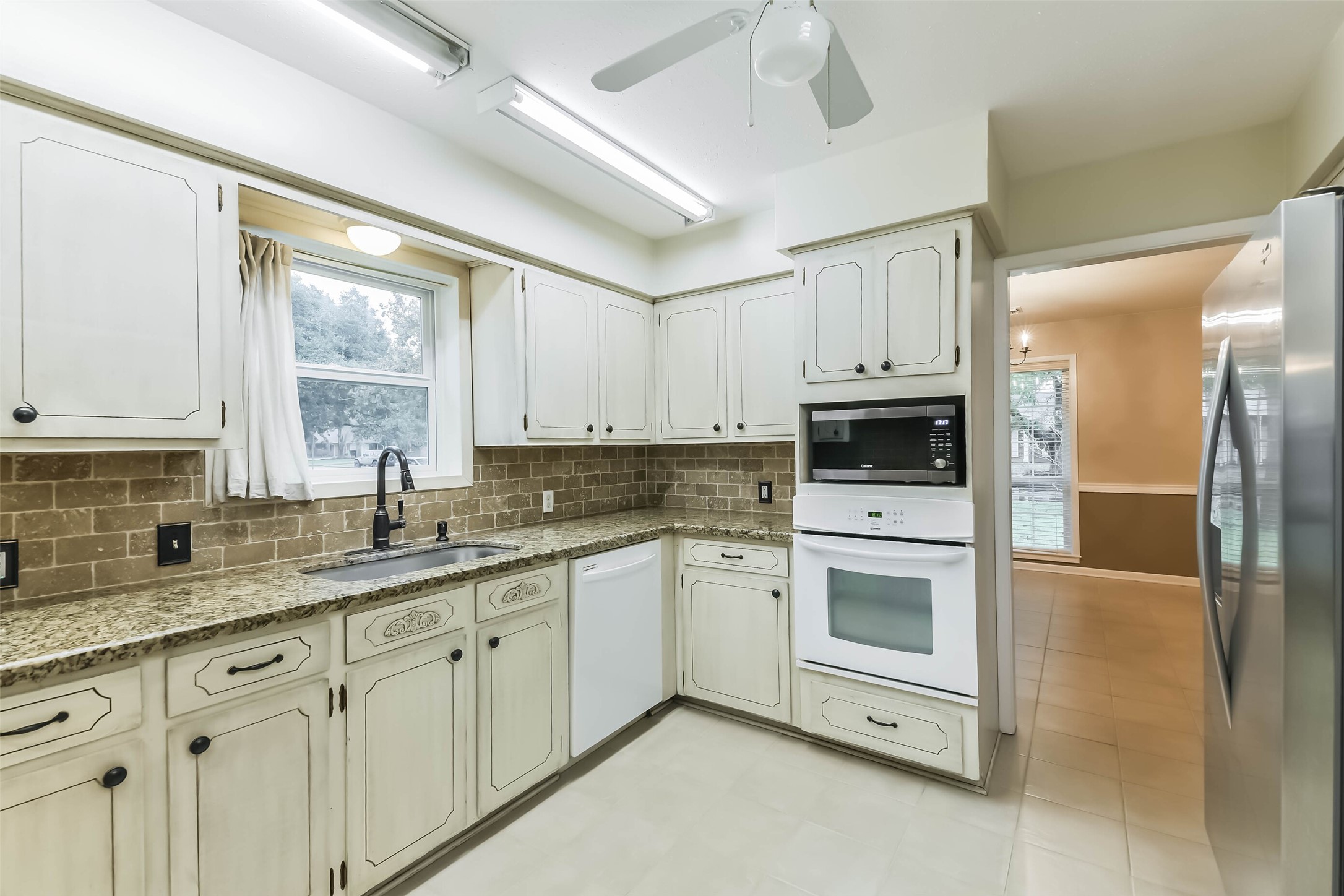 1210 Timber Lane Rosenberg, TX 77471 - Photo 9 of 48 a kitchen with granite countertop white cabinets and white appliances