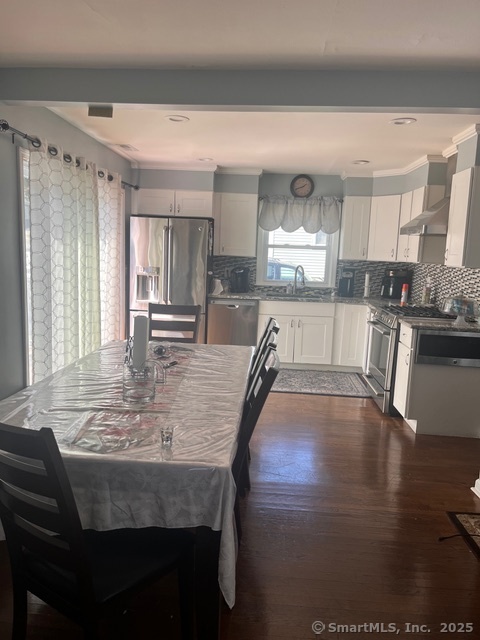 196 Monroe Street Milford, CT 06460 - Photo 21 of 31 a kitchen with stainless steel appliances granite countertop a stove a refrigerator a sink a dining table and chairs with wooden floor