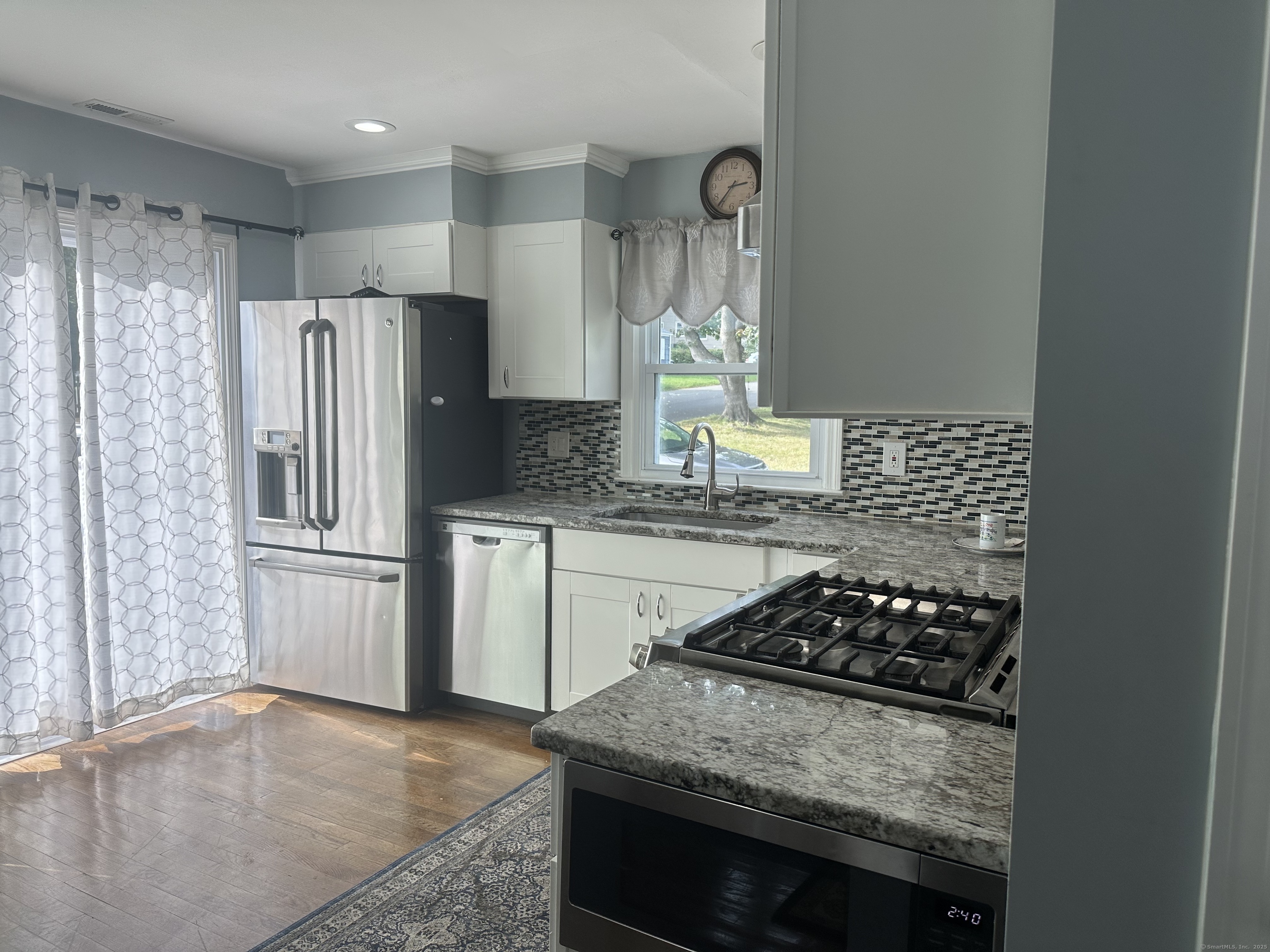 196 Monroe Street Milford, CT 06460 - Photo 5 of 31 a kitchen with granite countertop stainless steel appliances a sink stove and refrigerator