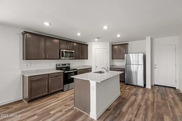 a kitchen with stainless steel appliances granite countertop a refrigerator stove microwave and sink