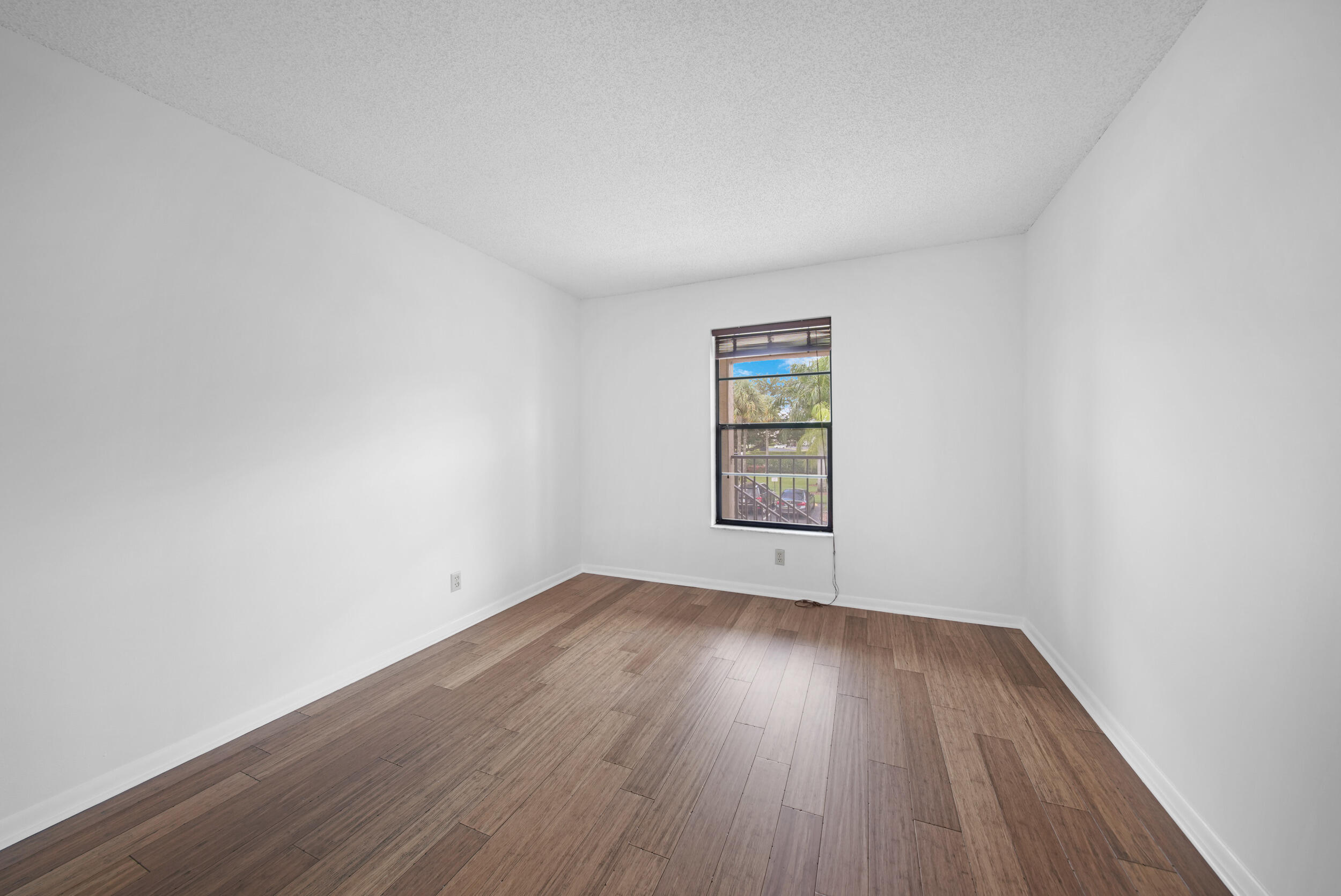 9480 Boca Cove Circle, Unit 415 Boca Raton, FL 33428 - Photo 13 of 25 an empty room with wooden floor and windows