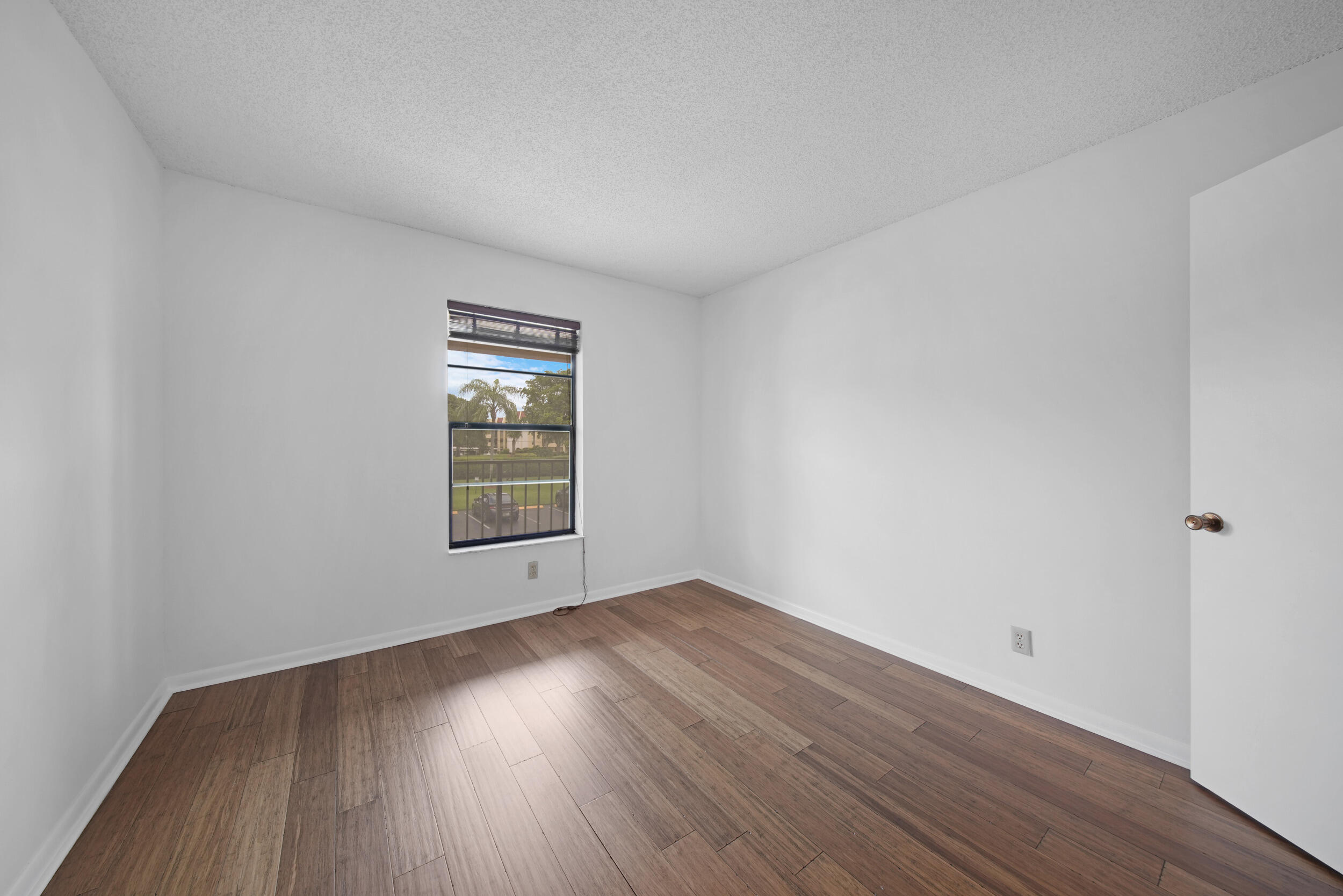 9480 Boca Cove Circle, Unit 415 Boca Raton, FL 33428 - Photo 15 of 25 a view of an empty room with wooden floor and a window