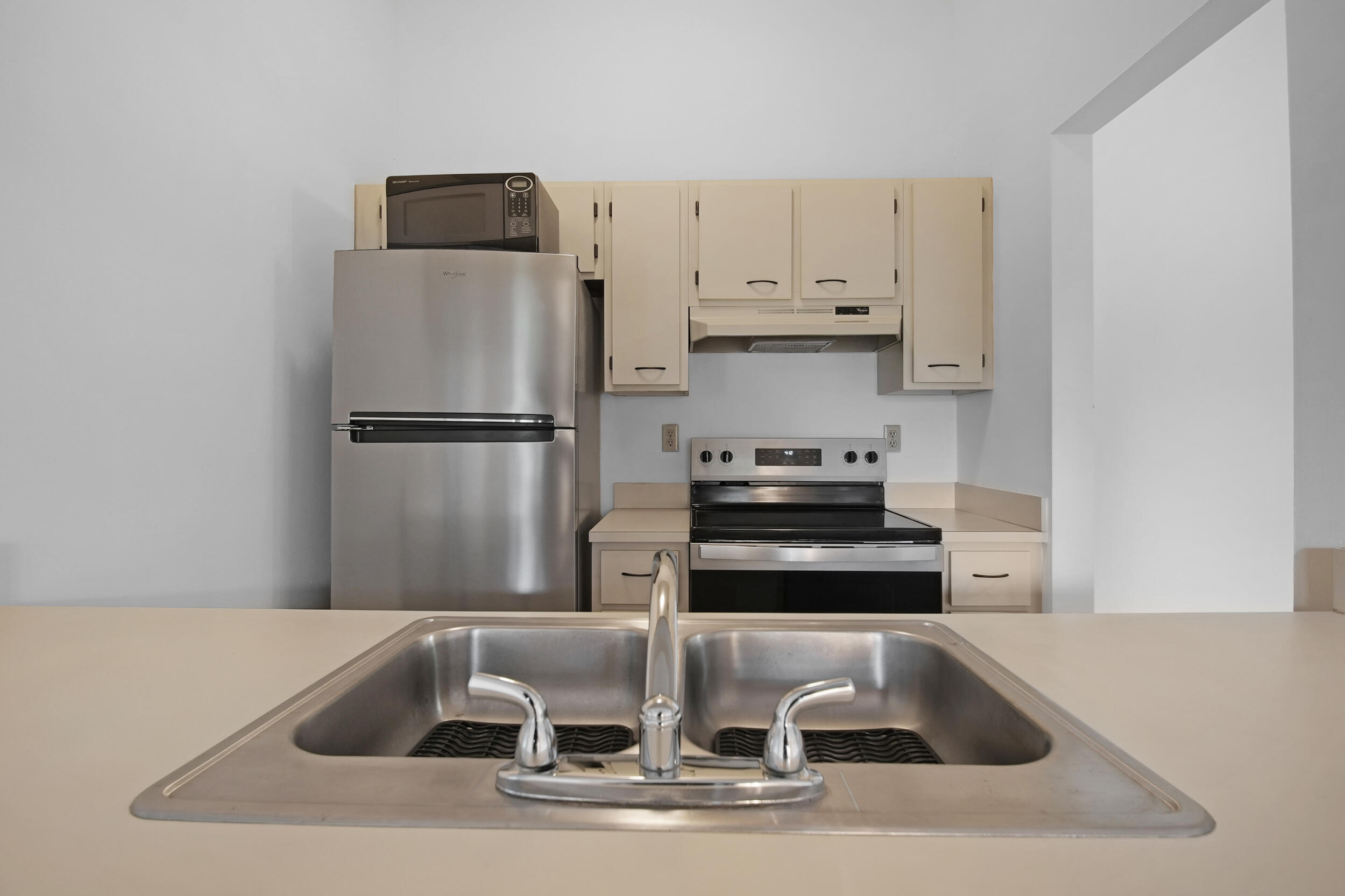 9480 Boca Cove Circle, Unit 415 Boca Raton, FL 33428 - Photo 8 of 25 a kitchen with white cabinets and stainless steel appliances
