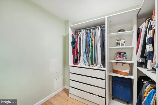 a view of walk in closet with clothes and shoes