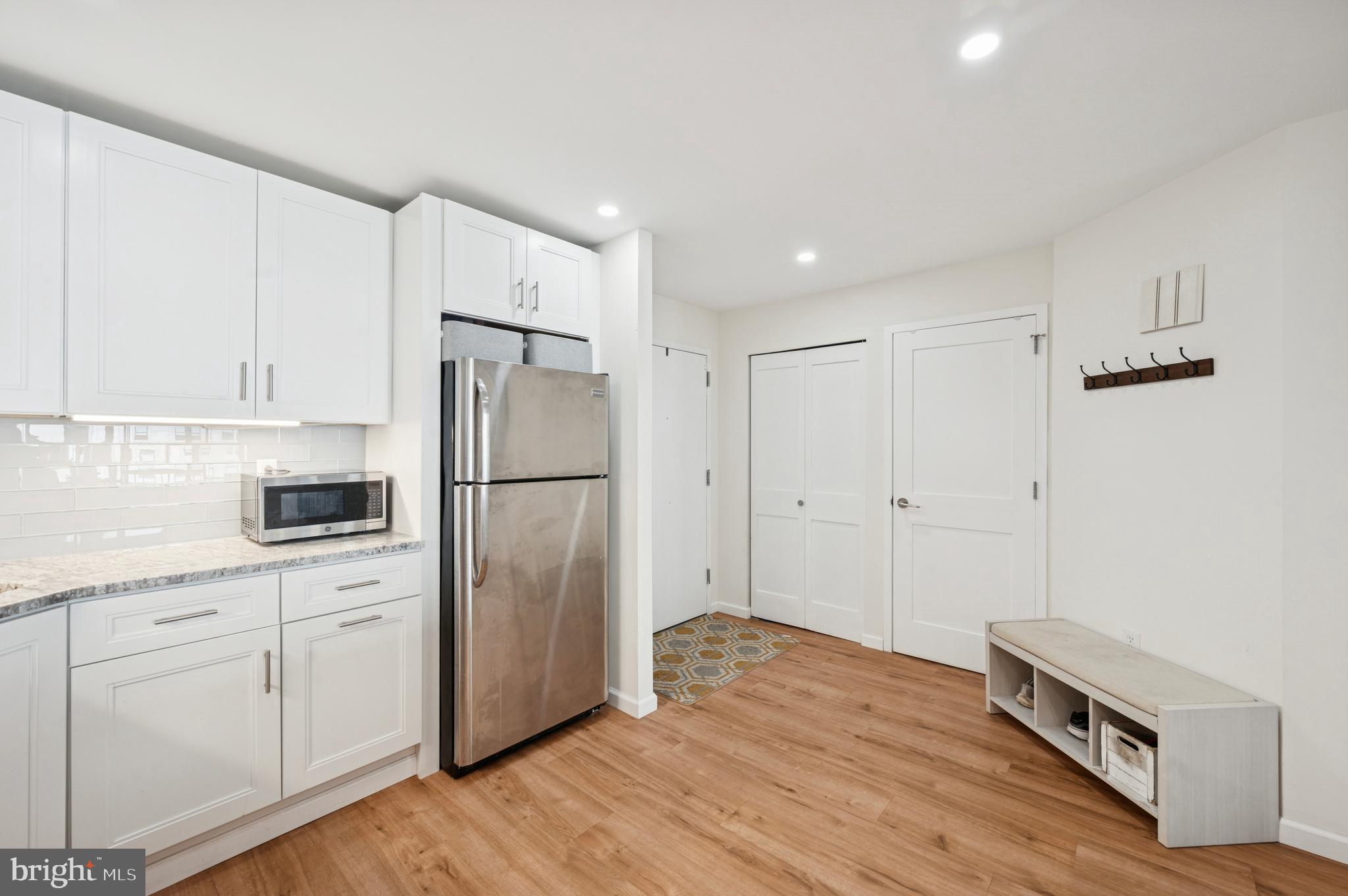 233 South 6th Street, Unit 904 Philadelphia, PA 19106 - Photo 13 of 16 a kitchen with a refrigerator a stove and white cabinets