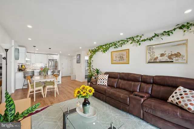 a living room with furniture flowerpot and wooden floor